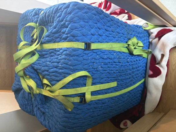 横浜市泉区でドラム式洗濯機を1階から2階へ荷上げ。養生材と紐で固定して搬入している様子